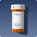 Immortals Medicine Men's Hair Complex amber prescription bottle on a blue background, personalized prescription treatment for hair loss