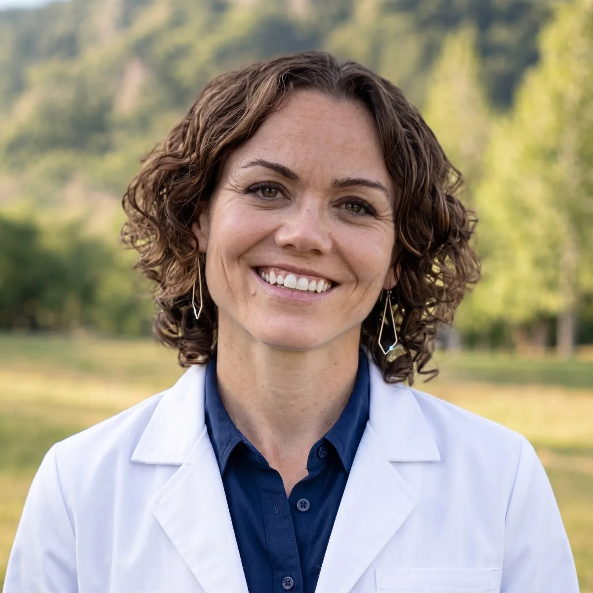 Hillary Seger, MD, MPH, MSCP, in a white coat, smiling outdoors