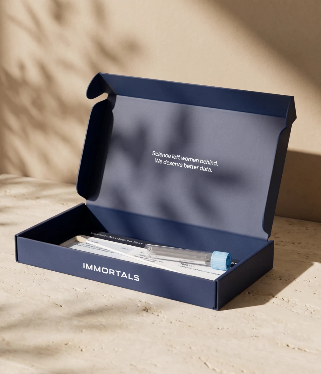 Open Immortals test kit with swab and sample tube on a stone surface in soft sunlight